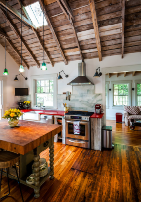 Bucătăria unei cabane transformată într-un spațiu rustic care se deschide către grădină