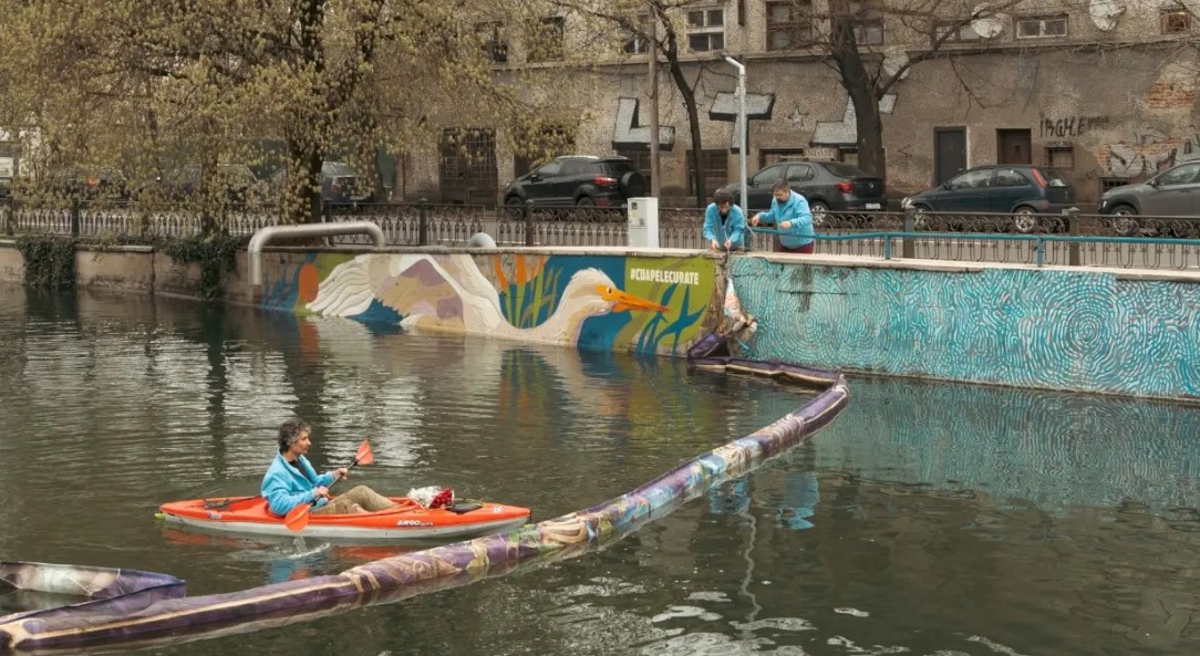 Bariere plutitoare pentru oprirea deşeurilor instalate pe râul Dâmbovița de către asociaţia „Mai Mult Verde”. În cadrul evenimentului, pe mal a fost desenată o egretă